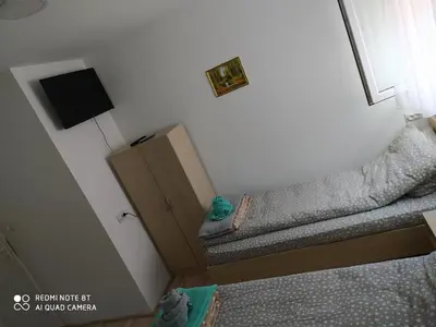 a small bedroom with a bed and a tv at Guest House Vila Banjica in Pirot