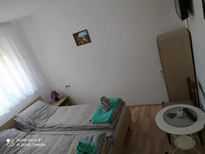 a small bedroom with a bed and a table at Guest House Vila Banjica in Pirot