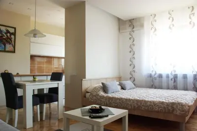 a small room with a bed and a table at Square Studio Apartment in Niš