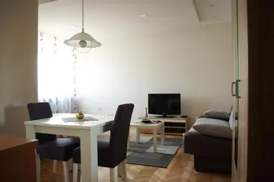 a living room with a white table and a couch at Square Studio Apartment in Niš