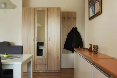 a kitchen with a wooden cabinet and a white table at Square Studio Apartment in Niš