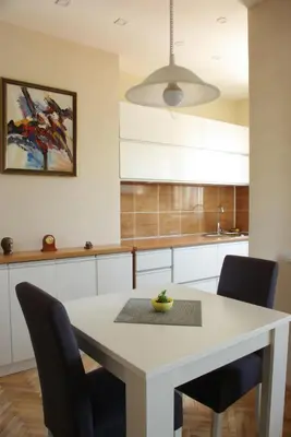 a kitchen with a white table and chairs at Square Studio Apartment in Niš