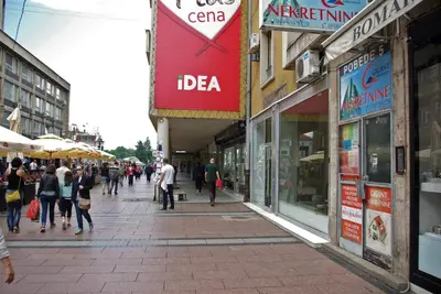 a group of people walking down a street in a city at Square Studio Apartment in Niš