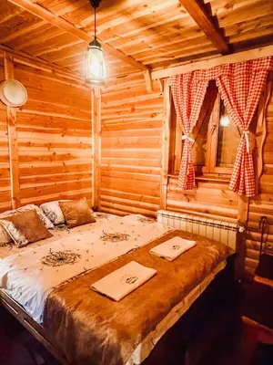 a bedroom with a bed in a log cabin at Apartment Snow Garden in Kopaonik