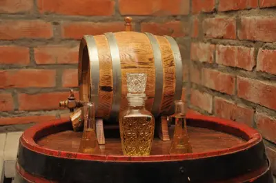 a wooden barrel with a bottle and three glass bottles at Apartment Snow Garden in Kopaonik