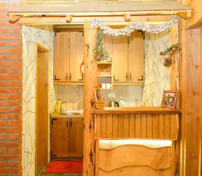 a kitchen with wooden cabinets and a sink at Apartment Snow Garden in Kopaonik