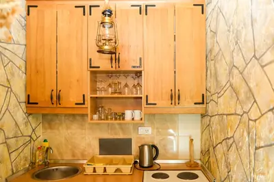 a kitchen with wooden cabinets and a sink at Apartment Snow Garden in Kopaonik