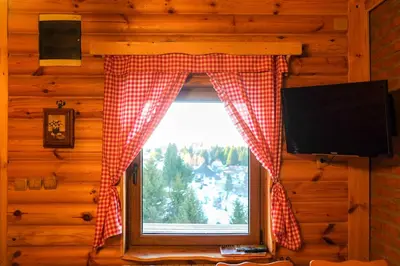 a window with a red and white checkered curtain at Apartment Snow Garden in Kopaonik