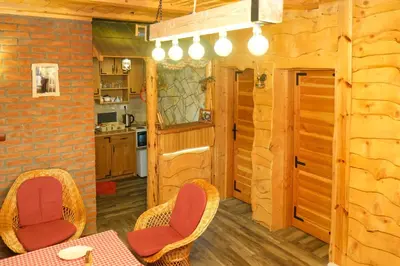 a kitchen with a table and chairs in a cabin at Apartment Snow Garden in Kopaonik