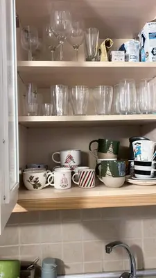 a kitchen shelf filled with dishes and glasses at Apartment Marija- Kopaonik centar in Kopaonik