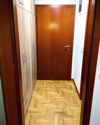 a hallway with a wooden door and a wooden floor at Apartmani Tamara in Vrnjačka Banja