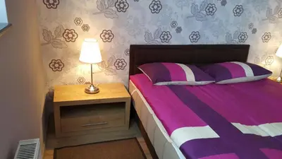 a bedroom with a bed and a table with a lamp at KOP Centar Aviator in Kopaonik