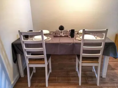 a dining room table with two chairs and a gray table cloth at KOP Centar Aviator in Kopaonik