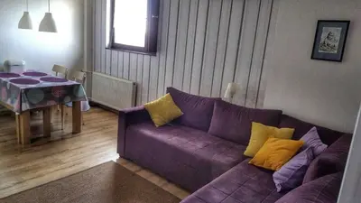 a living room with a purple couch and a table at KOP Centar Aviator in Kopaonik