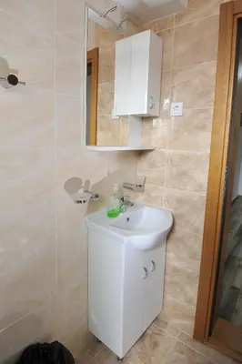a bathroom with a white sink and a mirror at Dobricin Konak Apartmani in Kopaonik