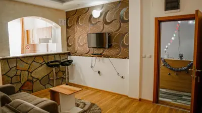 a living room with a couch and a tv on a wall at Dobricin Konak Apartmani in Kopaonik