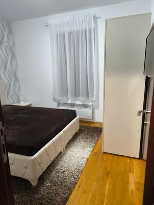 a bedroom with a bed and a door with a window at Alex apartman in Vrnjačka Banja