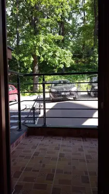 a view from the door of a porch with a bench at Alex apartman in Vrnjačka Banja
