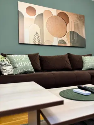 a living room with a brown couch and a table at Alex apartman in Vrnjačka Banja