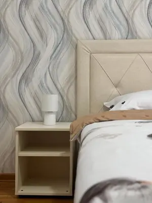 a bedroom with a bed and a side table with a candle at Alex apartman in Vrnjačka Banja