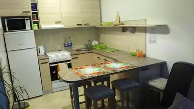 a kitchen with a counter with a table in it at Smiley Apartman in Vrnjačka Banja