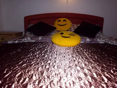 two smiley faces are sitting on a bed at Smiley Apartman in Vrnjačka Banja
