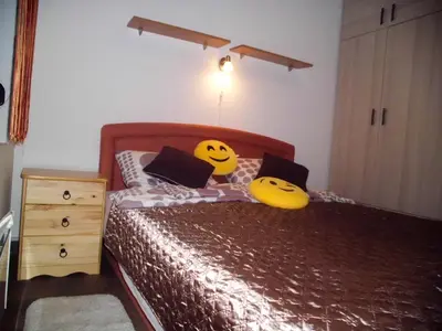 a bedroom with a bed with yellow pillows with smileys on it at Smiley Apartman in Vrnjačka Banja