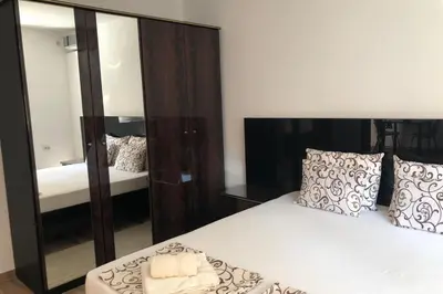 a bedroom with a bed and a large mirror at Apartments Ivan in Niš