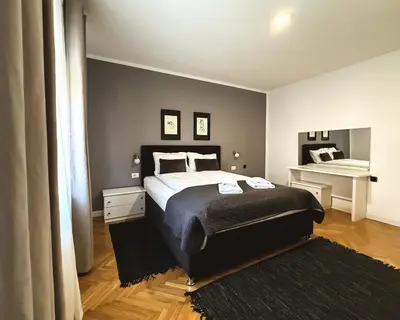 a bedroom with a large bed and a piano at Apartments Velickovic in Soko Banja