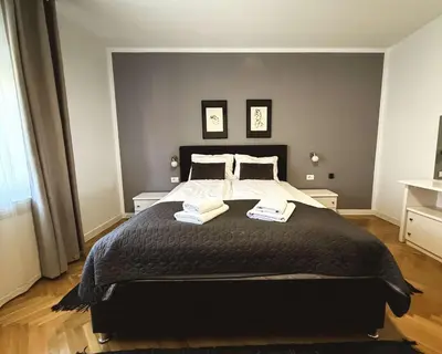 a bedroom with a large black bed with two pillows at Apartments Velickovic in Soko Banja