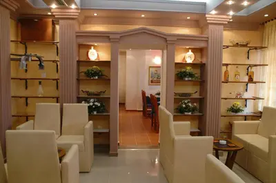 a waiting room with chairs and tables and shelves at Hotel Tehnograd in Kraljevo