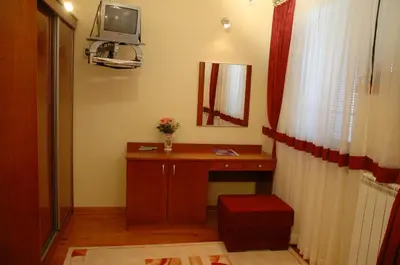 a room with a desk and a mirror and a table at Hotel Tehnograd in Kraljevo