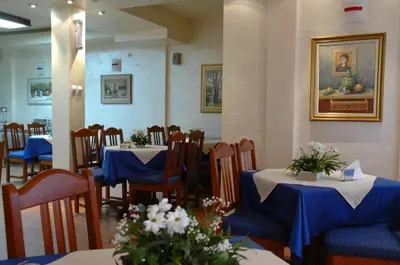a restaurant with tables and chairs with blue tablecloths at Hotel Tehnograd in Kraljevo