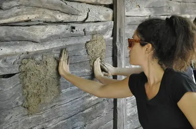 a woman standing next to a wall with dirt on it at Country house Dunjin Konak in Rogljevo