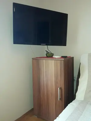 a flat screen tv on top of a wooden cabinet at Studio S Sokobanja in Soko Banja