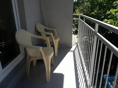 two white chairs sitting on a balcony at Studio S Sokobanja in Soko Banja