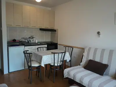 a kitchen with a table and chairs and a couch at Studio S Sokobanja in Soko Banja