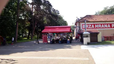 a store with a red awning next to a street at Apartmani LolaNola in Vrnjačka Banja
