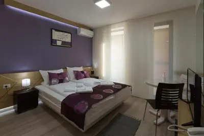 a bedroom with a large bed and a table in it at B&B Nataly 2 in Soko Banja