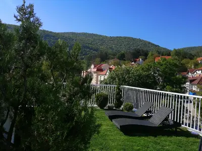 two benches sitting on the grass with a white fence at B&B Nataly 2 in Soko Banja