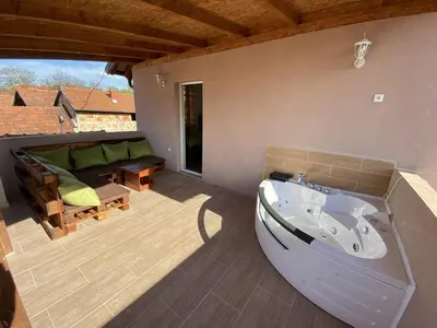 a bath tub sitting on a patio with a couch at Apartments Zlatko in Soko Banja