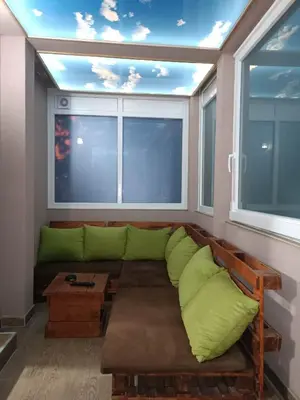 a living room with a green couch in front of a window at Apartments Zlatko in Soko Banja