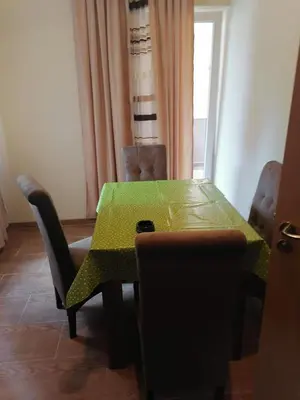 a dining room with a green table and chairs at Apartments Zlatko in Soko Banja