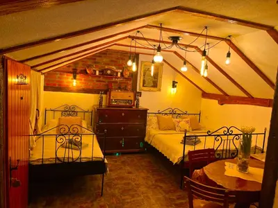 a bedroom with two beds and a room with two tables at Etno selo Stanojevic in Boljevac