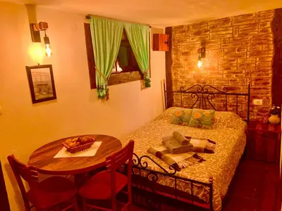 a bedroom with a table and a bed and a table and chairs at Etno selo Stanojevic in Boljevac