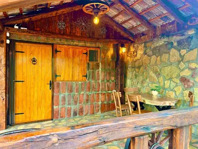 a room with a wooden door and a table in a stone building at Etno selo Stanojevic in Boljevac