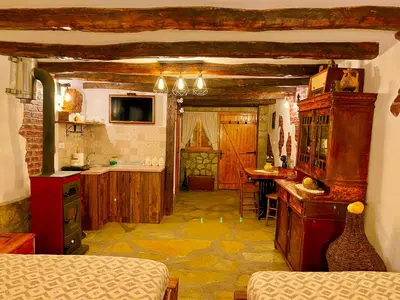 a room with a kitchen with a bed and a table at Etno selo Stanojevic in Boljevac