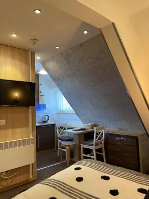 a room with a bed and a table with chairs at Apartment Dunja Konaci in Kopaonik