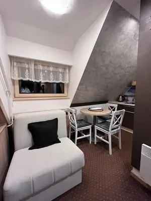 a small room with a bed and a table at Apartment Maja Konaci in Kopaonik