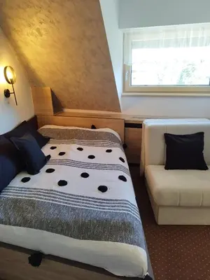 a bedroom with a bed and a couch and a window at Apartment Maja Konaci in Kopaonik